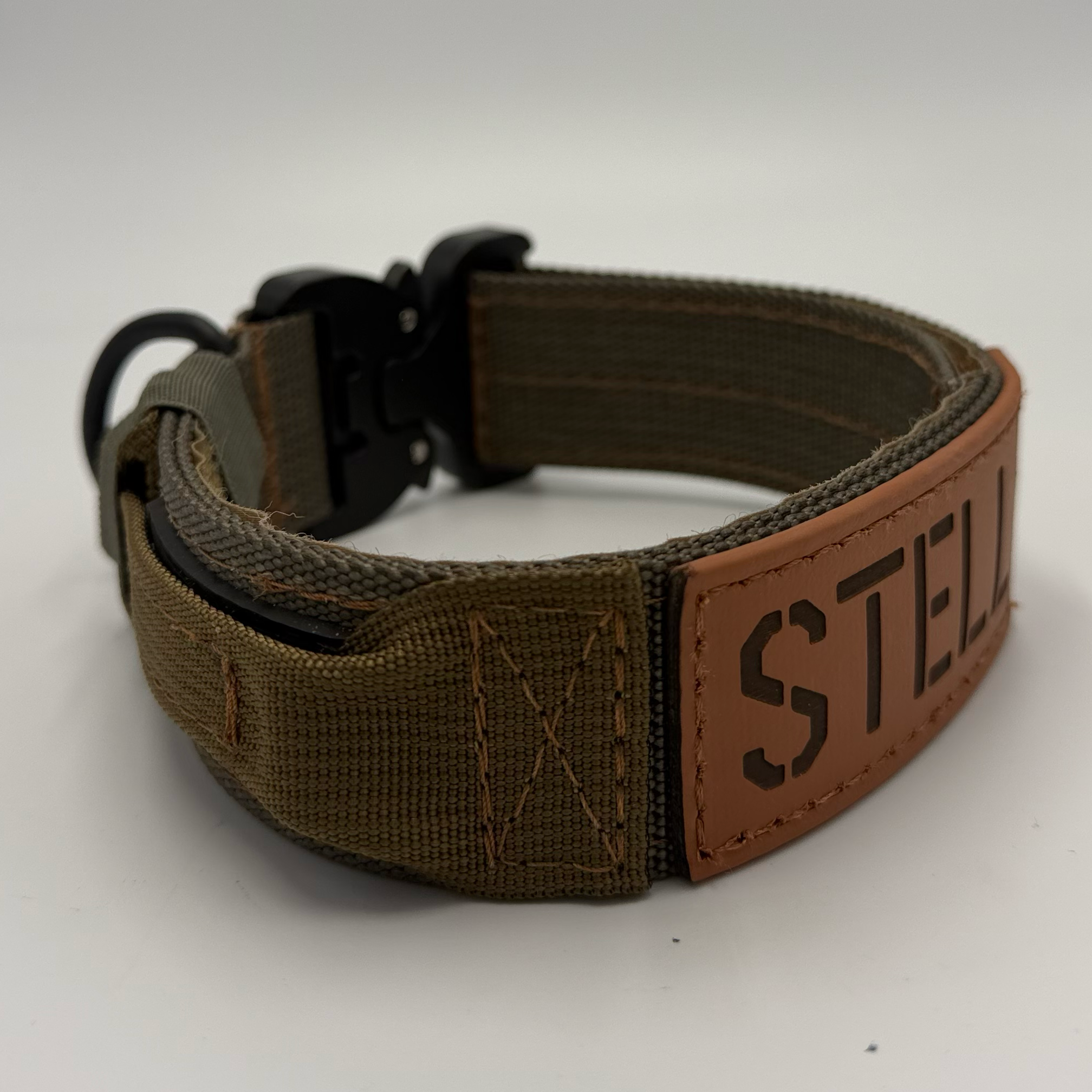 Titan Tactical Dog Collar featuring 1.5" Mil-Spec 4015 nylon webbing, a genuine AustriAlpin COBRA® buckle, RuffLock Retained Handle System, and the exclusive RuffTag Personalized BioThane Identification System. Handmade in the USA by American Ruffneck Collars. Biothane Tag close up. Side view.