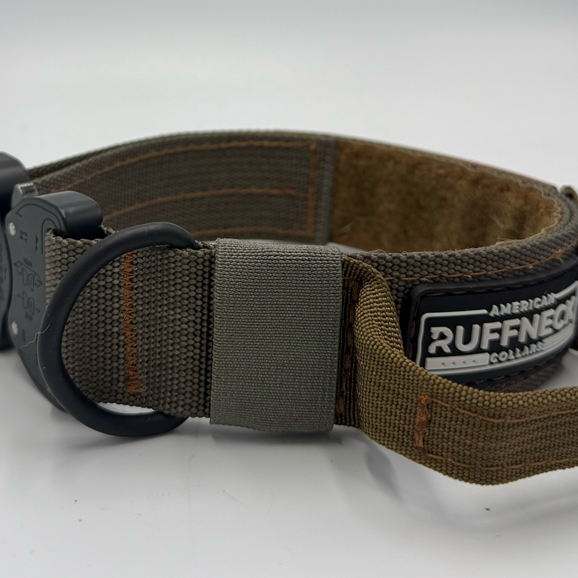Titan Tactical Dog Collar featuring 1.5" Mil-Spec 4015 nylon webbing, a genuine AustriAlpin COBRA® buckle, RuffLock Retained Handle System, and the exclusive RuffTag Personalized BioThane Identification System. Handmade in the USA by American Ruffneck Collars. view of deployed handle and elastic from the RuffLock Retained Handle System.