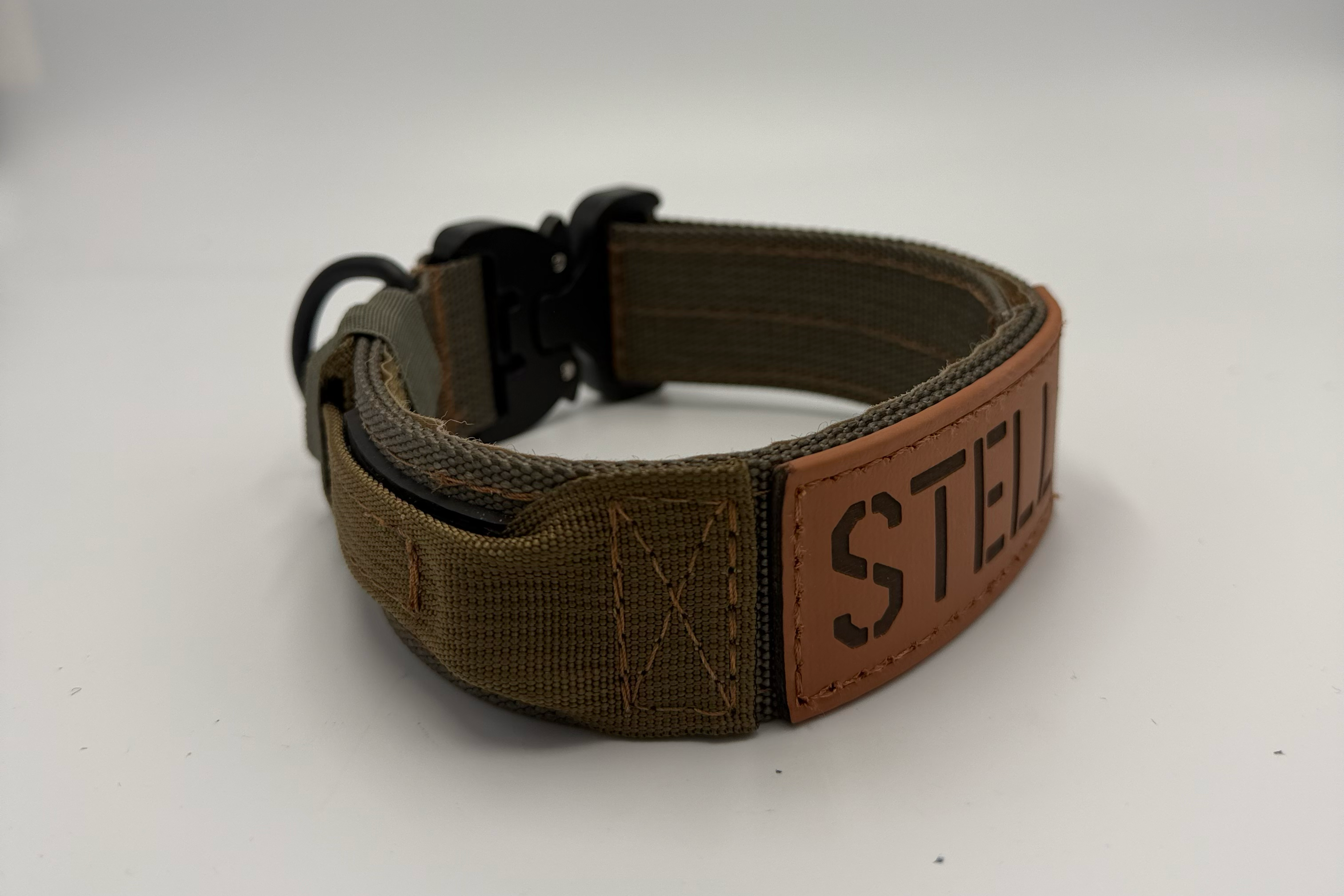 Titan Tactical Dog Collar featuring 1.5" Mil-Spec 4015 nylon webbing, a genuine AustriAlpin COBRA® buckle, RuffLock Retained Handle System, and the exclusive RuffTag Personalized BioThane Identification System. Handmade in the USA by American Ruffneck Collars. Biothane Tag close up. Side view. 